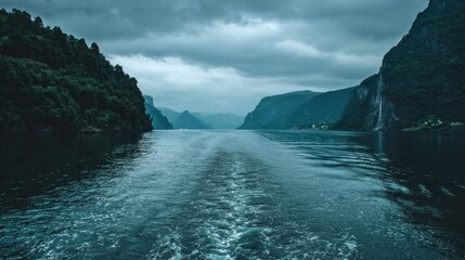 Dramatic seascape view of a fjord with mountains and cloudy sky scenic landscape