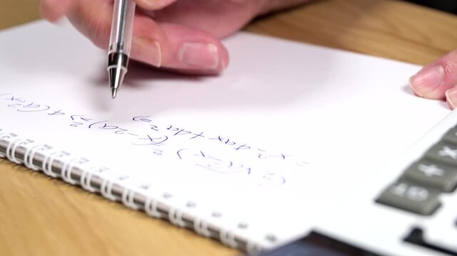 student is solving a difficult equation on blank paper