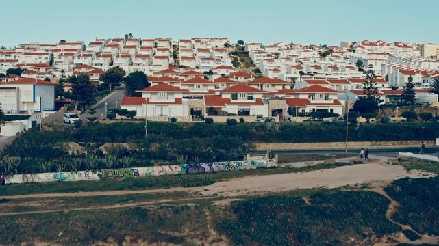 Drone is lift off over Beautiful European touristic city  in Portugal. Aerial view - white houses with orange roofs in the tourist region of Portugal. Beautiful cityscape in the morning.