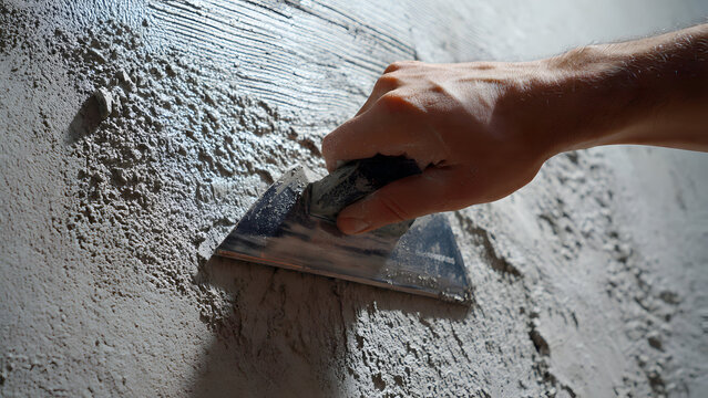 Photorealistic image gloved hand drywall taping knife smooth plaster renovation