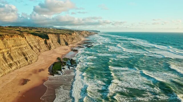 Drone aerial view over long rocky coastline in Magoito, Portugal, on summer sunny day. Beautiful natural landscape with ocean rocky shore. Drone is flying over  Scenic European tourist destination.