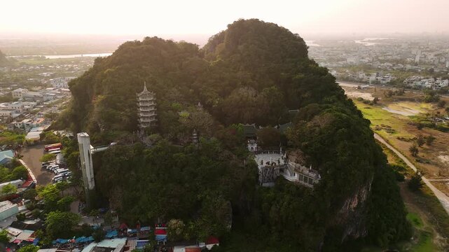 Aerial view of marble mountains pagoda in da nang, vietnam, with a panoramic cityscape at sunset