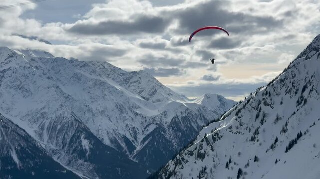 Paragliding flight over snowy Chamonix mountains France