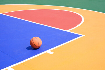 Naklejka premium Basketball on colorful outdoor sport court surface, Sports field background with copy space