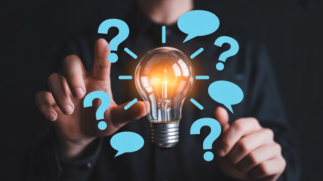 Person touching a glowing light bulb surrounded by question marks and speech bubbles, symbolizing ideas and solutions