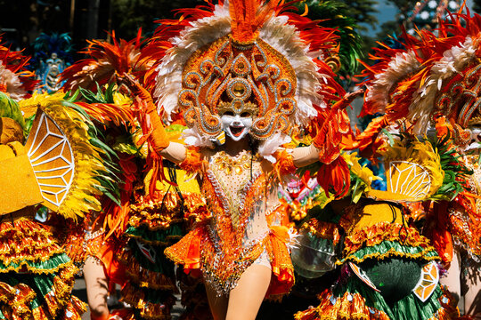 Cebu City, Philippines - 18 January 2026: View of vibrant Sinulog dancers adorned in elaborate costumes, a kaleidoscope of orange, white and gold, moving with rhythmic energy.