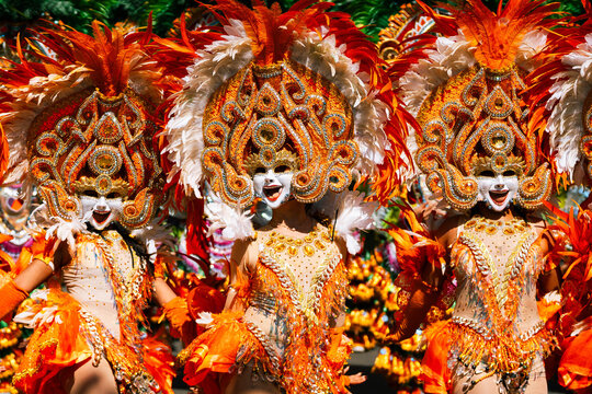 Cebu City, Philippines - 18 January 2026: View of vibrant Sinulog Festival dancers adorned in elaborate orange and white costumes, masks, and feathered headdresses, exuding festive energy.