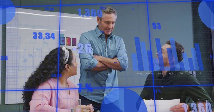Leading manager wearing blue shirt presenting metrics at conference table, holding papers and glass