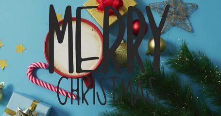 Resting red mug holding hot cocoa on blue tabletop, with candy cane, gift, MERRY CHRISTMAS text