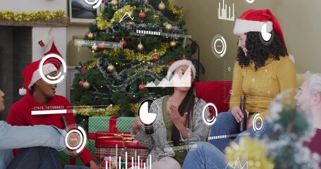 Naklejka premium Chatting group wearing Santa hats, sitting around Xmas tree with presents at home showing overlays