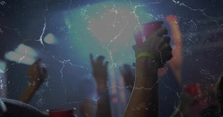 Raising forearm holding red cup during concert right side, neon wristband glowing, copy space