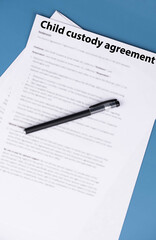Obraz premium Child custody agreement document on table, legal paperwork for parental rights, divorce settlement, and family law concept.