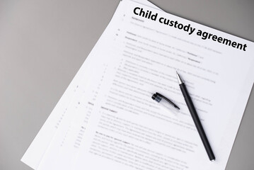 Child custody agreement document on table, legal paperwork for parental rights, divorce settlement, and family law concept.