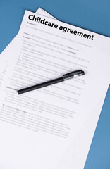 Fototapeta premium Childcare agreement contract on desk, legal document about child care services, parental responsibilities, and family support concept.