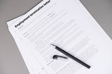Obraz premium Employment termination letter on office desk, official HR document about job dismissal and career transition, symbol of workplace decision, stress, and change in professional life.