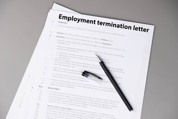 Obraz premium Employment termination letter on office desk, official HR document about job dismissal and career transition, symbol of workplace decision, stress, and change in professional life.