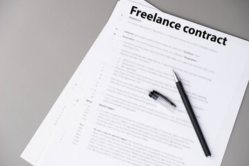 Obraz premium Freelance contract document on desk, professional agreement for remote work and creative collaboration, symbol of independence, flexibility, and modern digital business.