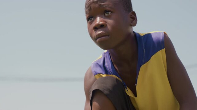 Young athlete focused. Single young sportsman poised mentally before intense training session. Isolated soccer player steeling himself mentally for rigorous practice under bright sunlight