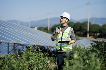 Fototapeta premium Engineer inspecting solar panels at a photovoltaic power station in the field