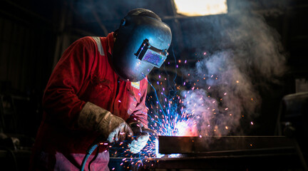 A welder working on a metal structure in a workshop