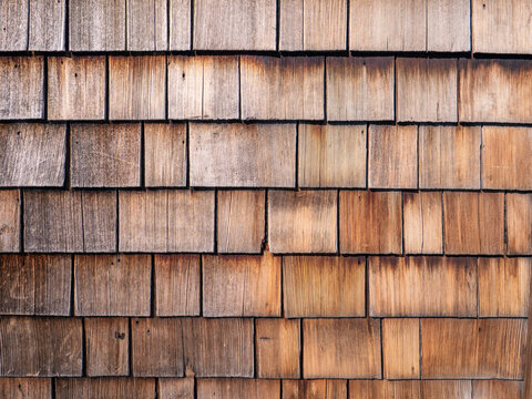 Natural weathered wooden shingles texture background, traditional rustic cedar shakes wall cladding pattern