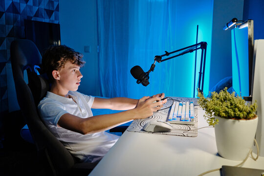 Teenage boy streaming video game playing on computer