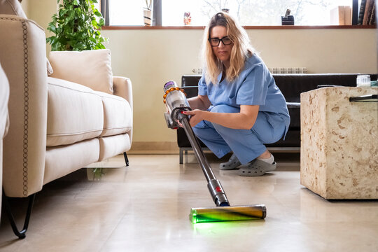 Woman cleaning house with vacuum cleaner