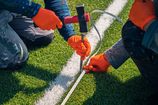Soccer field renovation teamwork with precise measurement