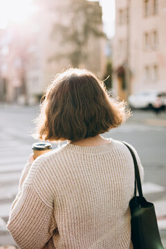 Woman walking in city with a coffee cup