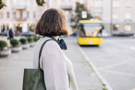 Woman waiting for a bus on an urban street