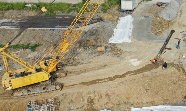 Yellow crane at construction site with workers in action