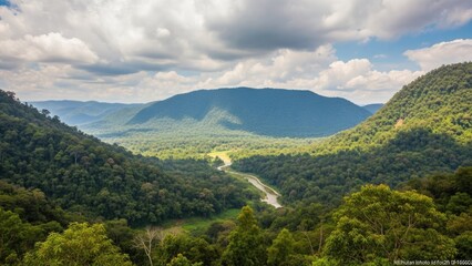 Obraz premium A serene landscape of rolling hills and mountains under a cloudy sky