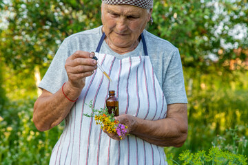 Old woman makes herbal tincture. Selective focus.