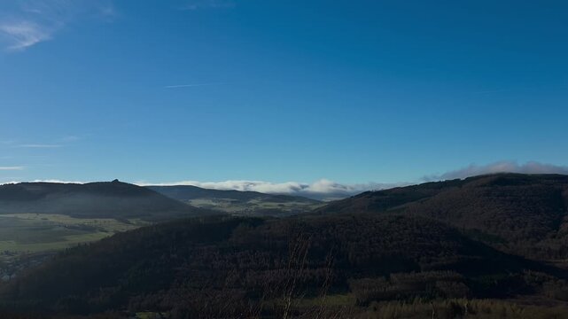 Time-lapse video, wide landscape with hills and clouds on the horizon, view from the Borberg towards Brilon-Wald or Elleringhausen, spring, hike in the Sauerland region, the Briloner Kammweg trail.