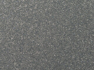 Macro photography of glossy silver grey metallic paint with fine sparkling particles.