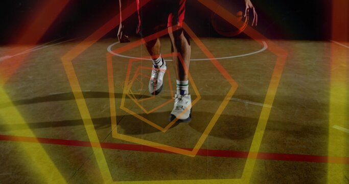 Dribbling player on gym court with ball by right hand, red shorts, shoes, painted arc, hexagons
