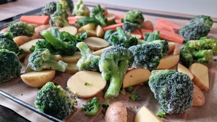 Frozen vegetables ready for cooking on a baking tray in a kitchen setting