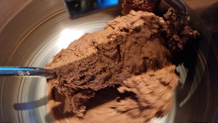 Mixing chocolate batter in a metal bowl for baking in a home kitchen