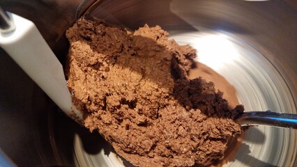 Mixing chocolate batter in a bowl during baking process in afternoon light