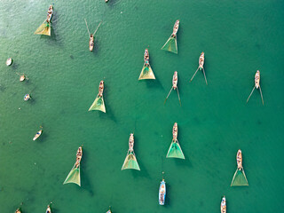 Aerial view of Vietnamese fishing boats in turquoise bay surrounded by tropical islands © AndriiDuhin