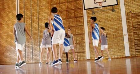 Playing students wearing blue-white jerseys and gray vests moving on school gym court, showing hoop © vectorfusionart
