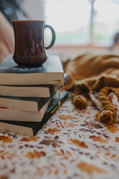 cup of coffee and books on a bed for a cozy relaxing fall day