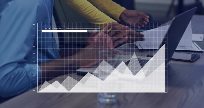 Woman leaning and showing paper to laptop, seated man typing while reviewing business overlay chart