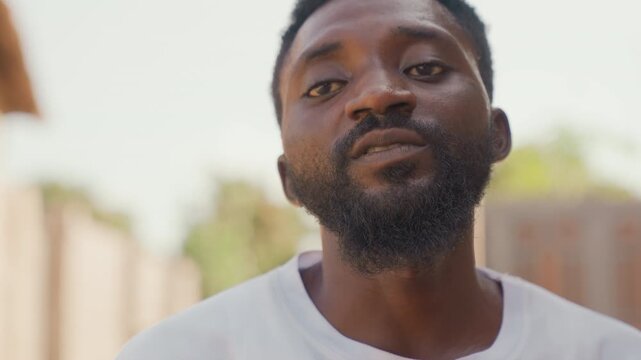 Confident athlete pose. Person confidently facing camera with firm stance and assertive expression. Individual presenting commanding presence with direct look and poised demeanor in sunlight
