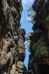Dramatic low angle view of an iron pedestrian bridge spanning between rocky cliffs in Saxon Switzerland National Park Germany. Scenic nature landscape, hiking, outdoor adventure