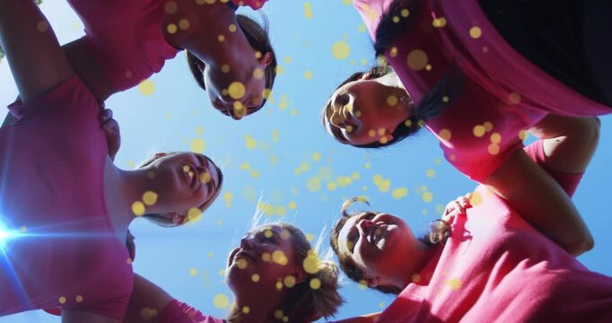 Five adults leaning into low-angle camera chanting sports cheer, yellow overlay drifting over faces