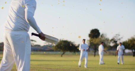 Obraz premium Holding wooden cricket bat, batsman wearing white kit at local park with gold confetti, copy space
