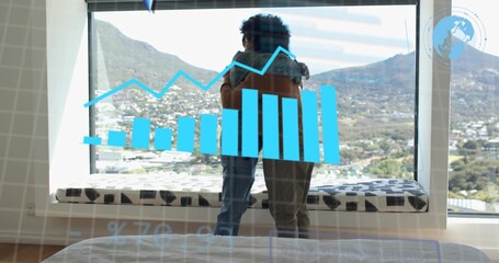Embracing father and son standing by floor-to-ceiling window in bedroom, showing chart overlay