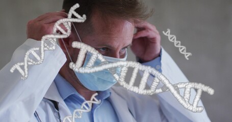 Adjusting doctor pulling surgical mask over face in clinic with lab coat stethoscope and DNA helix