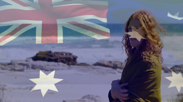Woman standing on rocky shore for travel, wind blowing hair, flag overlay shifting, covering torso